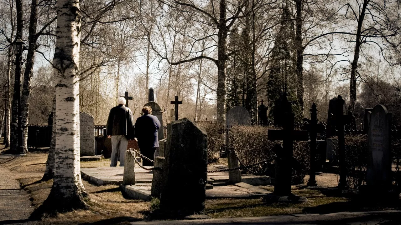 Kaksi ihmistä hautausmaalla.