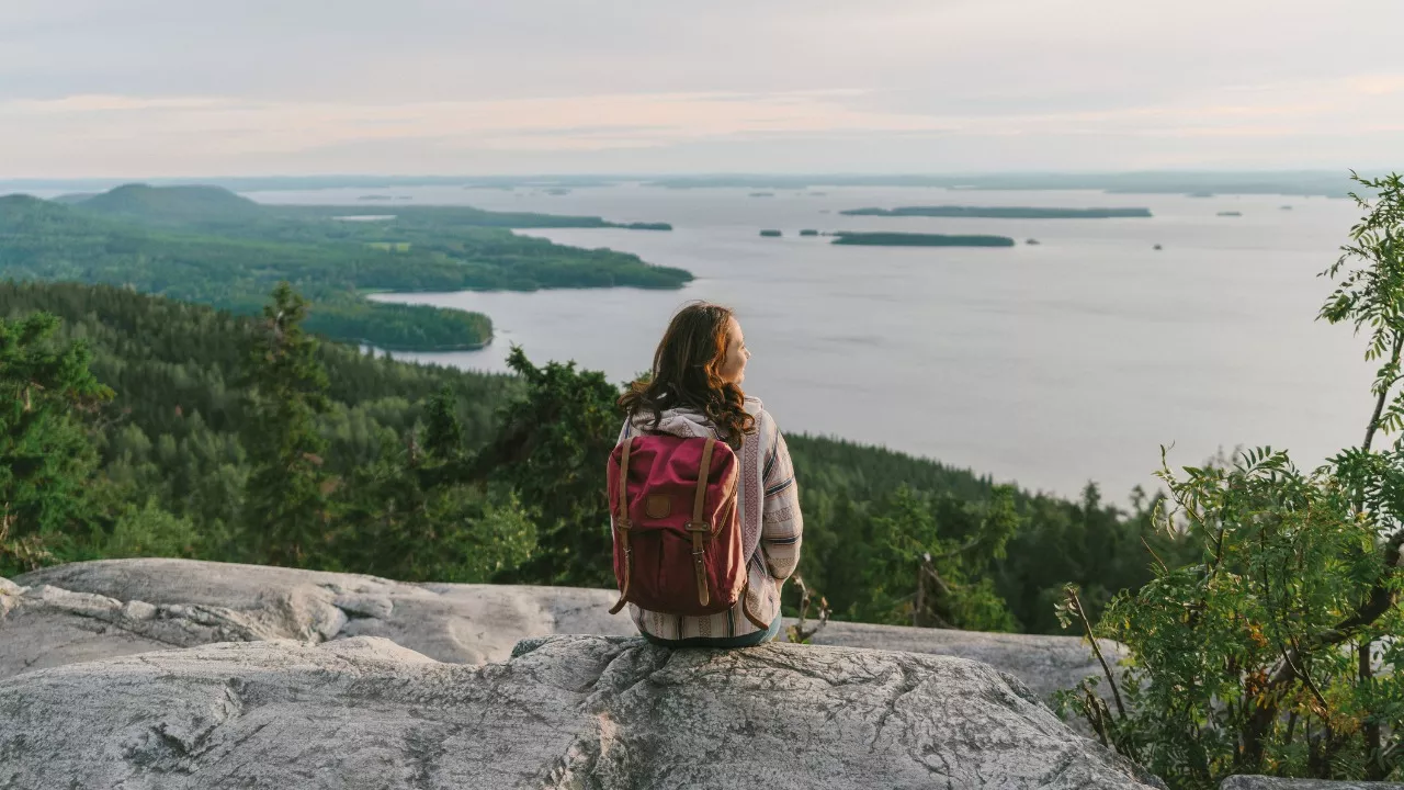 Suomen luontokohteet. Kuvassa nainen katselee järvelle.