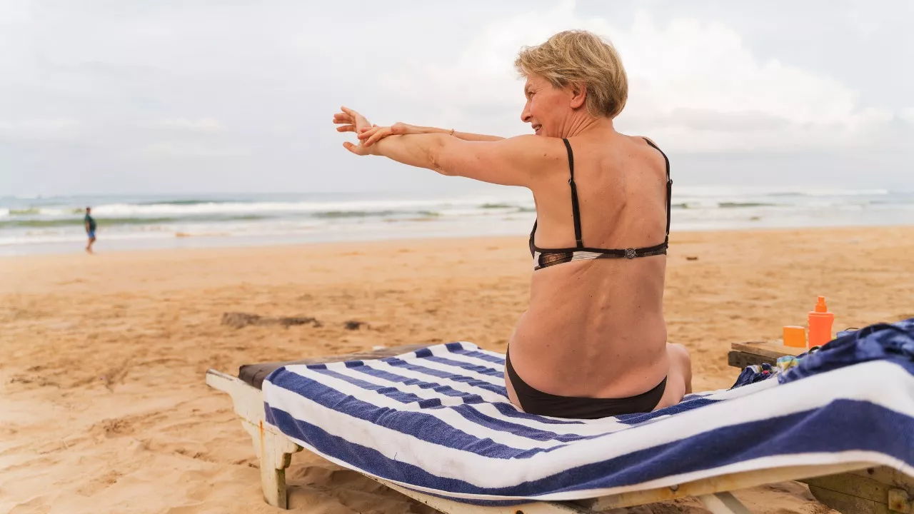 after sun -voide levittyy iholle, kun nainen istuu rannalla