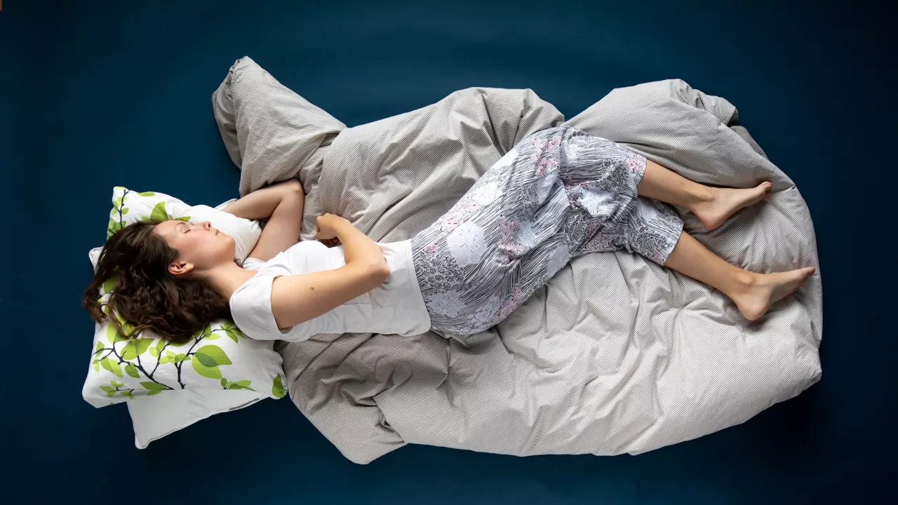 Nukkuma-asento: nainen nukkuu kyljellään