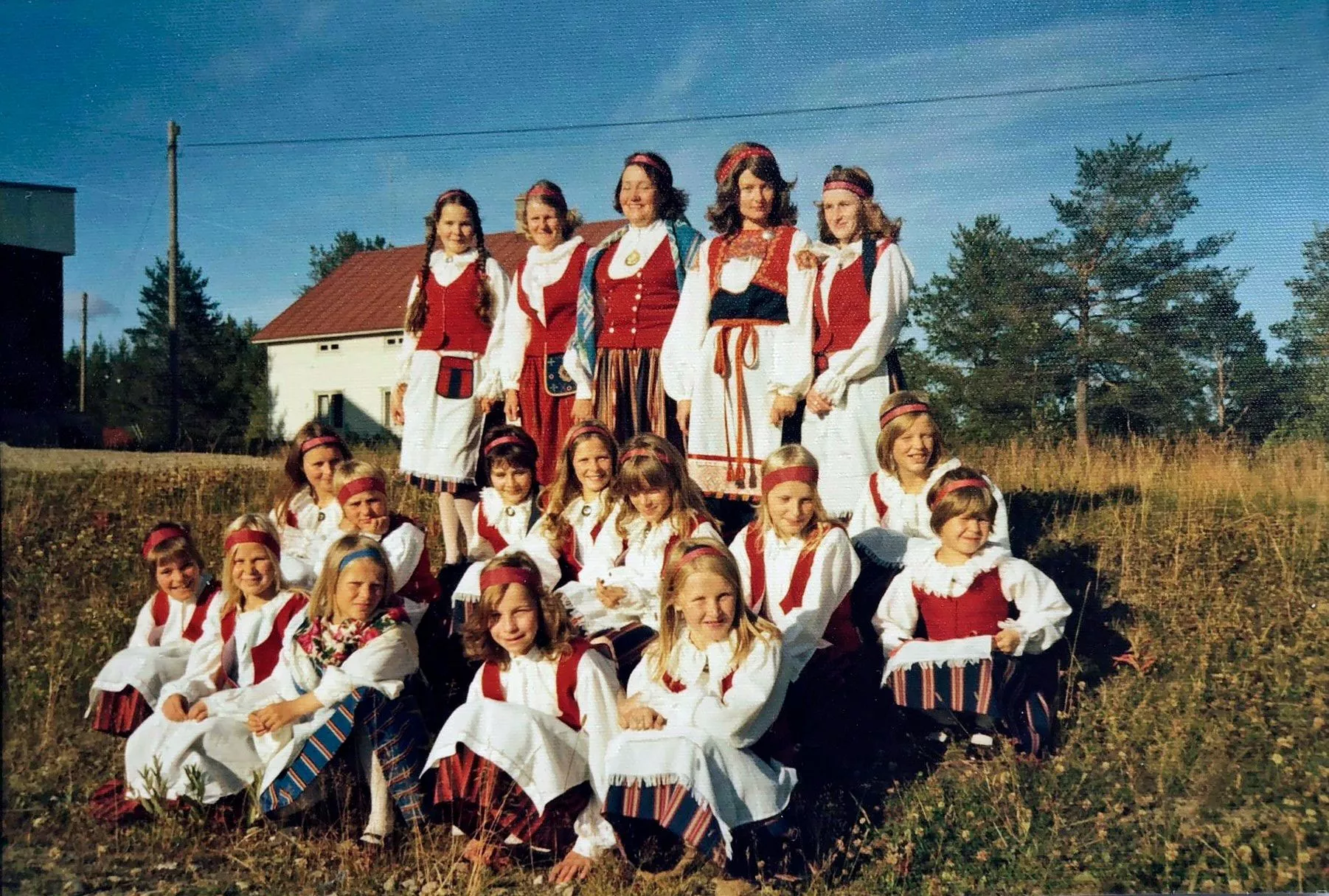 Juuri valmistuneita kansallis­pukuja Syväjärven kylässä 1970-luvun puolivälissä. Päivi istuu kuvassa oikealla. 