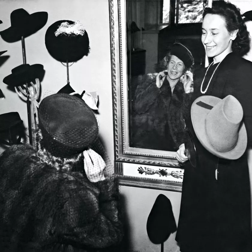 Nainen sovittaa hattua hattukaupassa vuonna 1941.