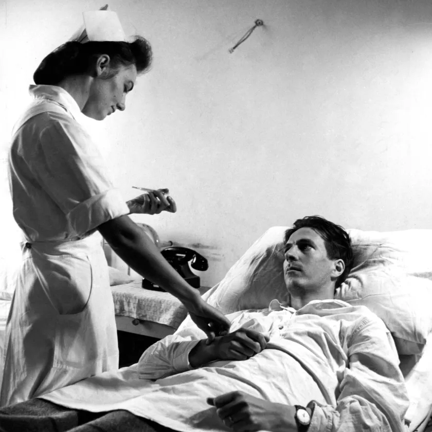 Sairaanhoitaja mittaa kuumetta potilaalta vuonna 1944.