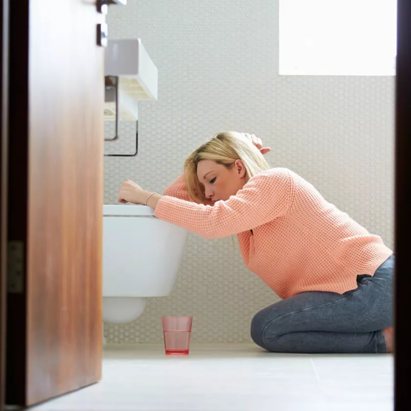 Oksennustauti eli vatsatauti piinaa naista, joka on kylpyhuoneessa