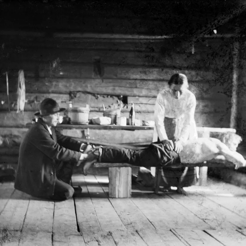 Parantaja hoitaa potilaan lonkkaa tuvassa vuonna 1917.