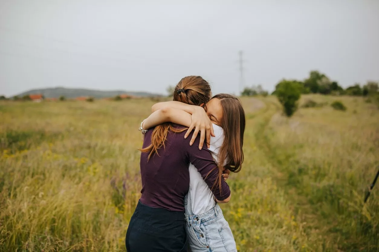 Kaksi tyttöä halaa toisiaan
