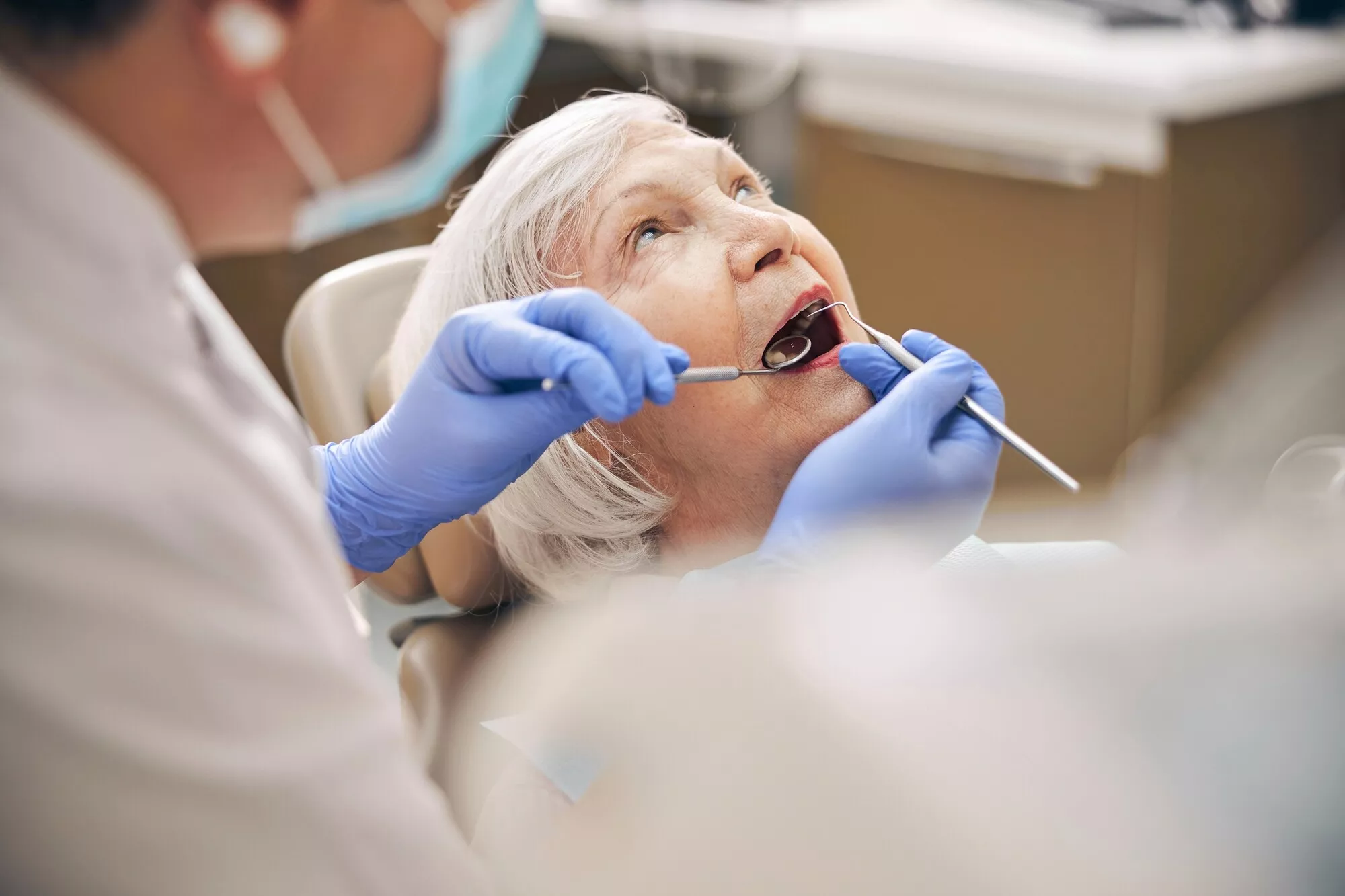 Naisen suuta tutkitaan hammaslääkärissä.