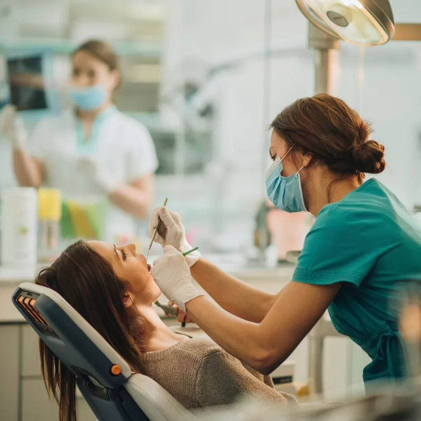 Suuhygienisti tutkii naisen hampaita, koska hampaiden vihlonta vaivaa naista