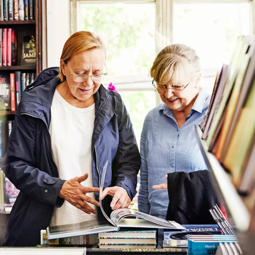 Kaksi naista selaa kirjaa Vinhan kirjakaupassa.