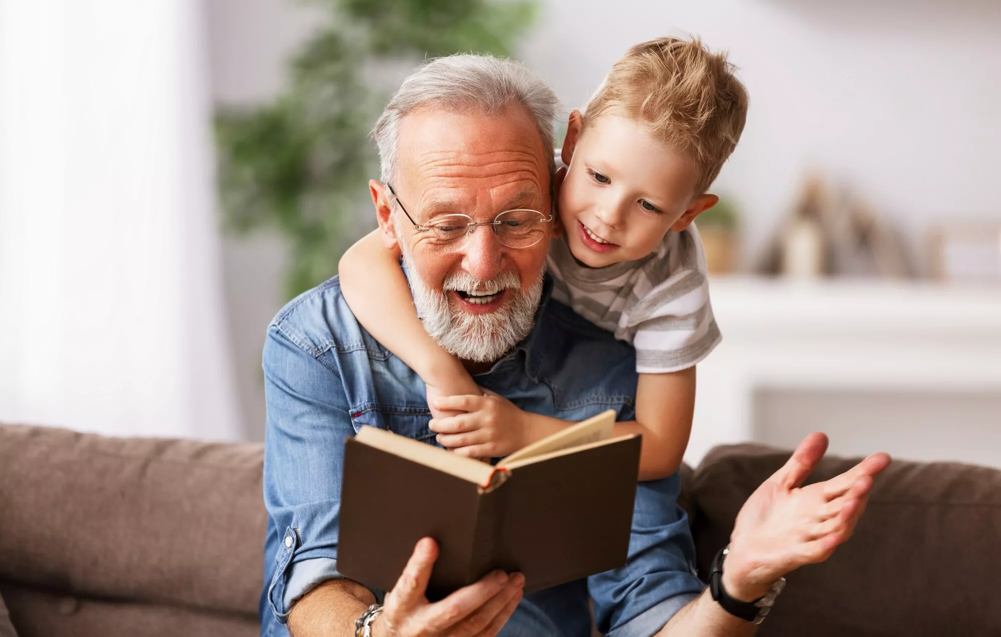 Isoisä lukee kirjaa pojalle.