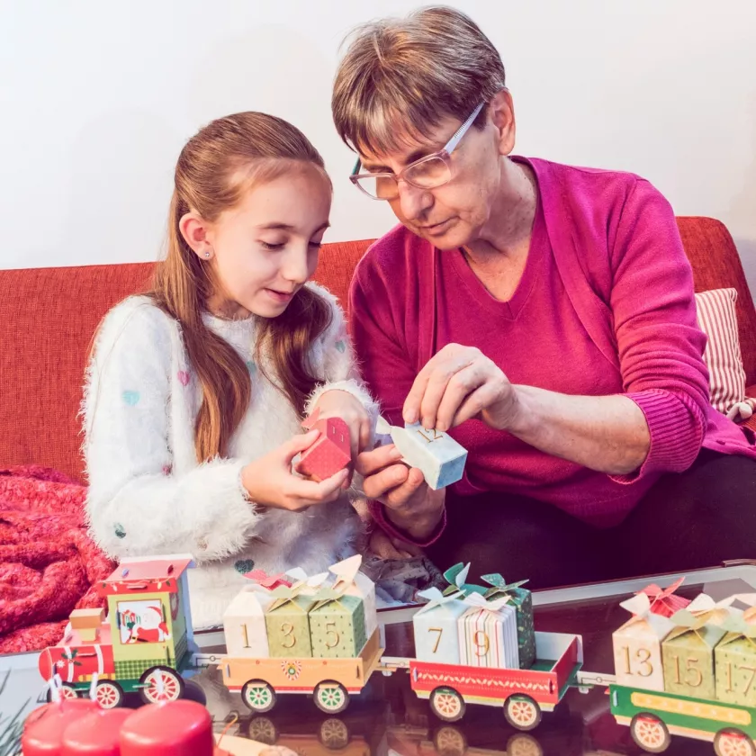 Joulukalenterit 2023: Aikuinen ja lapsi avaavat joulukalenterin luukkuja yhdessä.