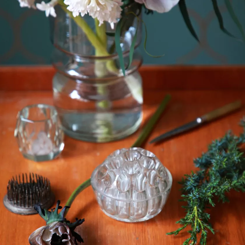 Kukkasiili ja lasinen kukkatuki pöydällä.