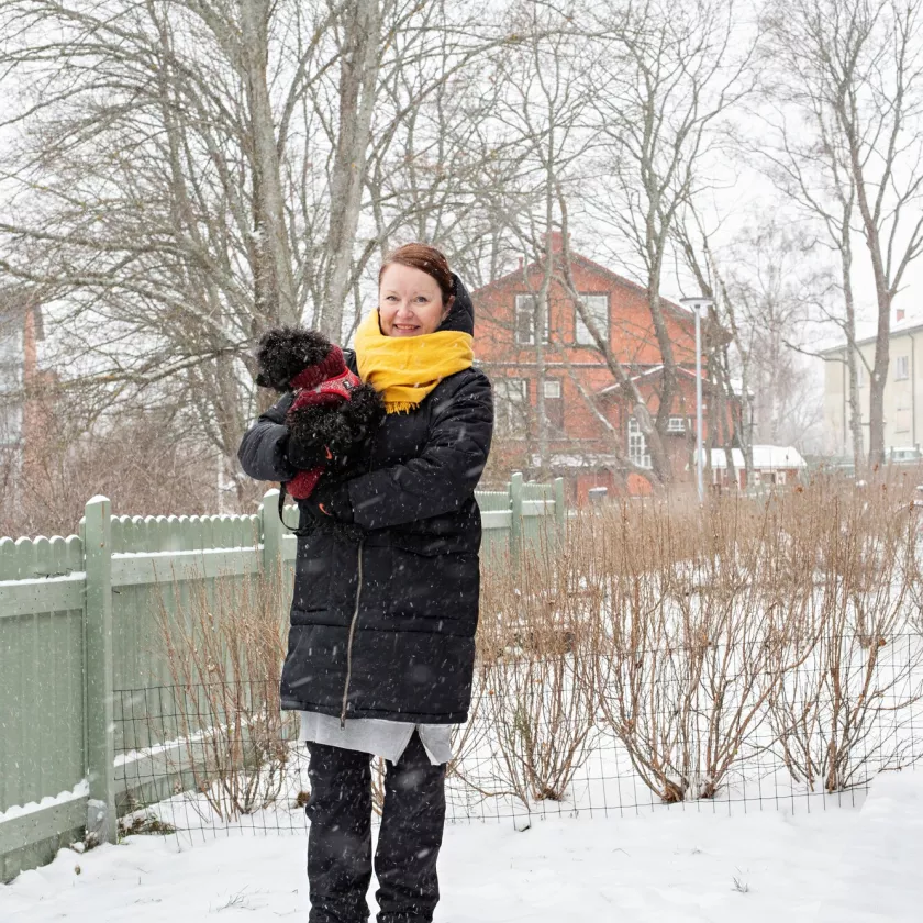 Keliakian oireet alkoivat jo nuorena. Mia seisoo talvisella pihalla koira sylissään.