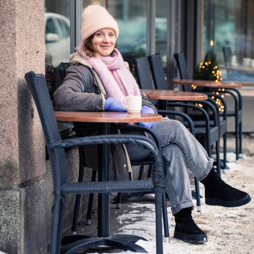 Elena Leeve istuu kahvilan terassilla talvella.