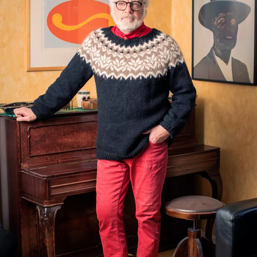 Uutisankkuri ja kirjailija Matti Rönkä kotonaan vanhan pianon ääressä. 
