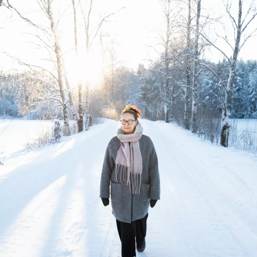 Atooppinen iho. Johanna Saastamoinen kävelee lumisella tiellä.