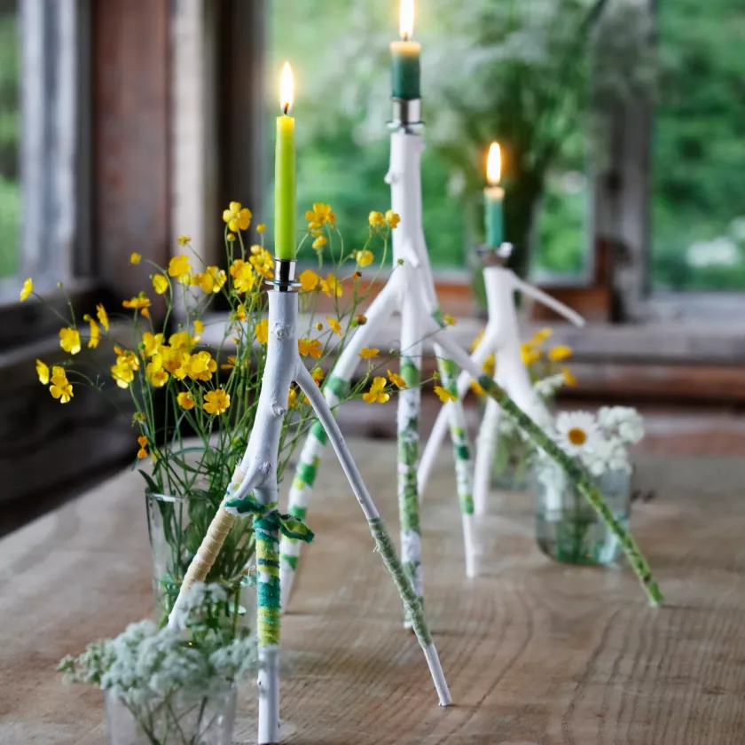 Oksanhaaroista askarrellut kynttilänjalat ovat näyttäviä mökkijuhlan somistajia.