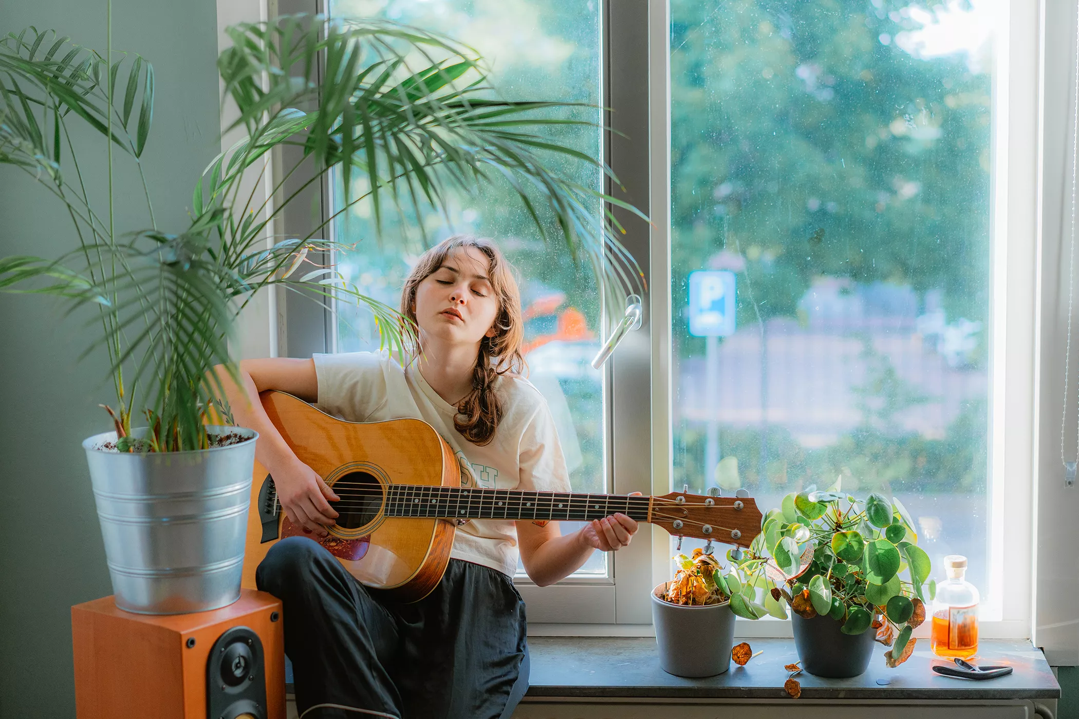 Nainen soittaa kitaralla musiikkia kasveille.