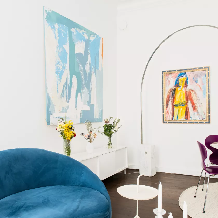 Vasemmassa alareunassa näkyy sininen sohva. Seinällä on sininen Sami Syköltä saatu maalaus.
