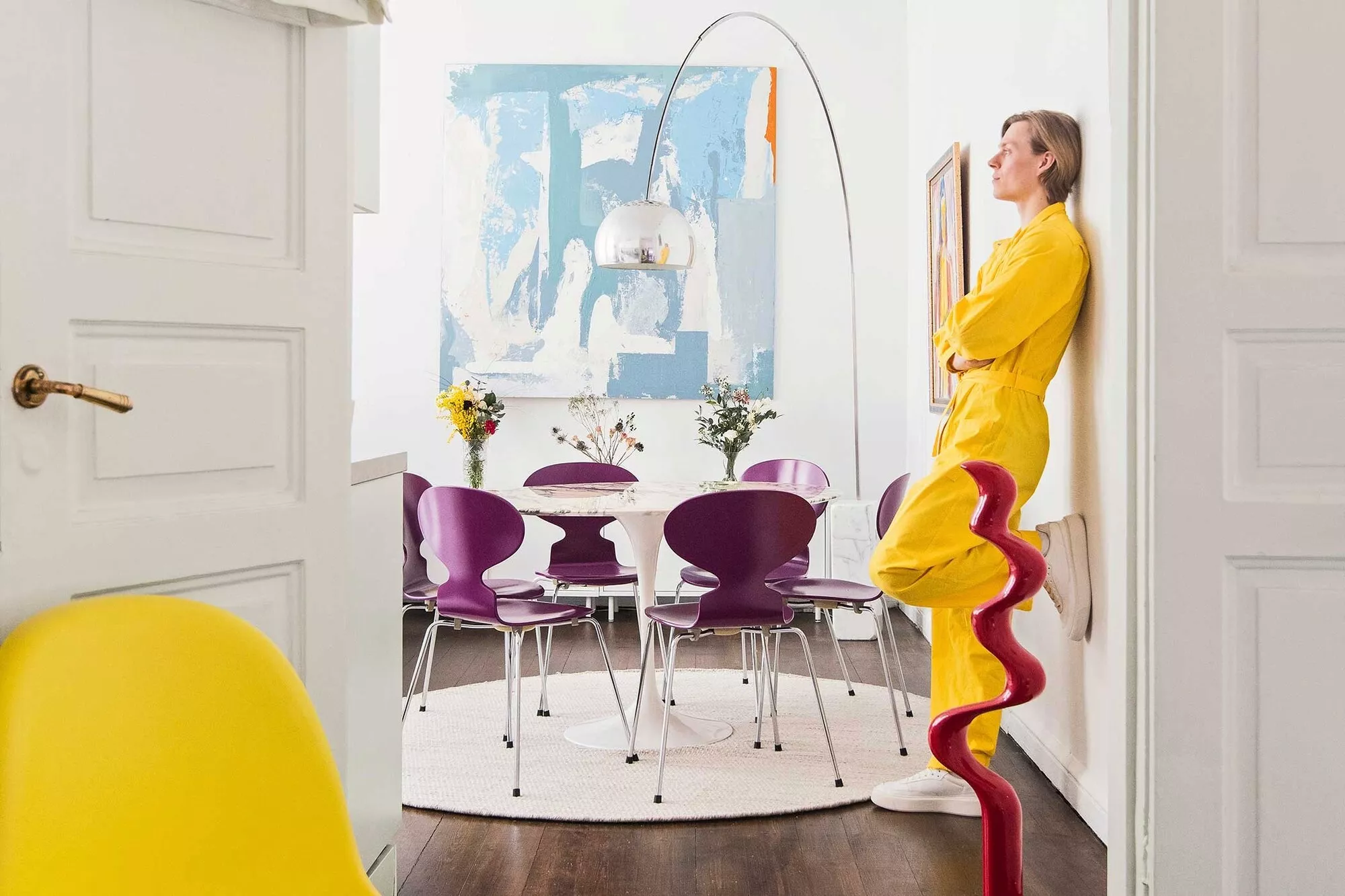 Balettitanssija Atte Kilpinen nojaa olohuoneensa seinään. Takana näkyvät Eero Saarisen Tulppaani-pöytä, Muurahais-tuolit sekä Flos Arco -valaisin.