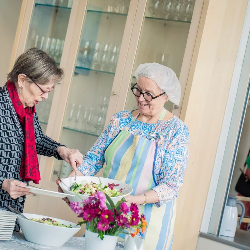 Yhteisöllinen senioritalo Kotisatamassa tarjoillaan lounas. Markut Helminen ottaa Leena Vahteran tarjoamaa salaattia.