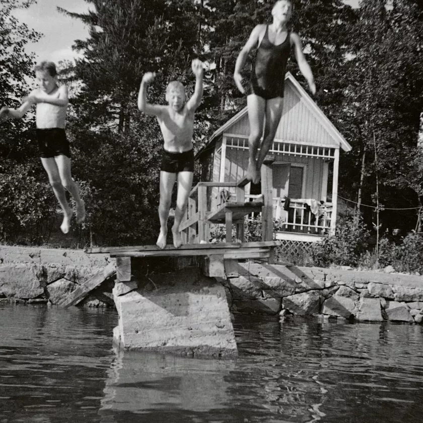 Lapset hyppäävät laiturilta veteen.