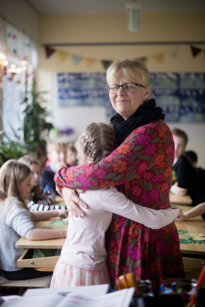 Opettaja Päivi Salminen halaa oppilastaan luokassa.