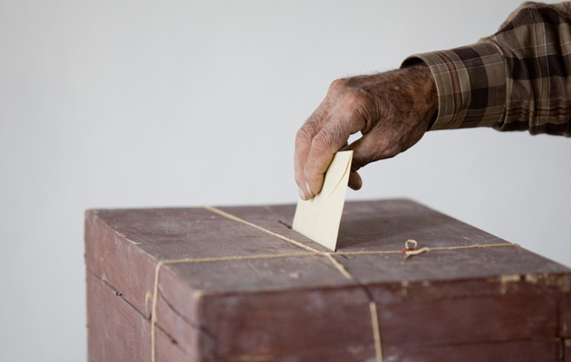Käsi laittaa äänestyslipukkeen vaaliuurnaan