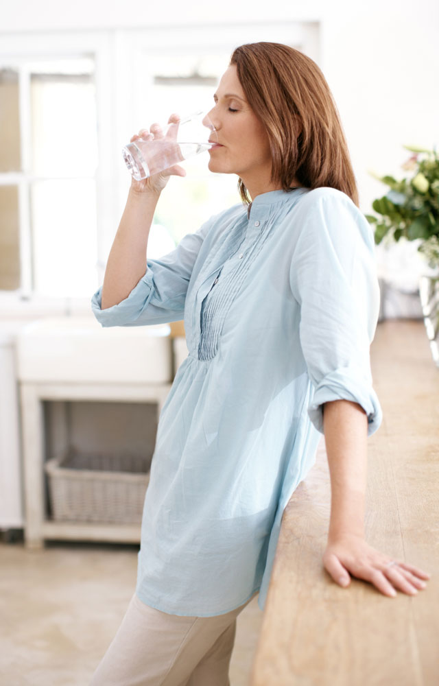 Estä nestehukka: nainen juo vettä lasista