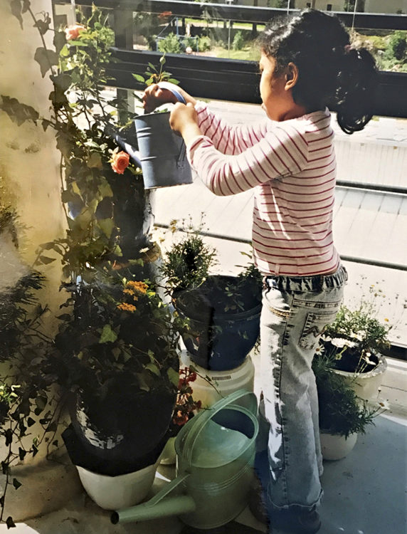 Puza Saha kastelee kukkia.