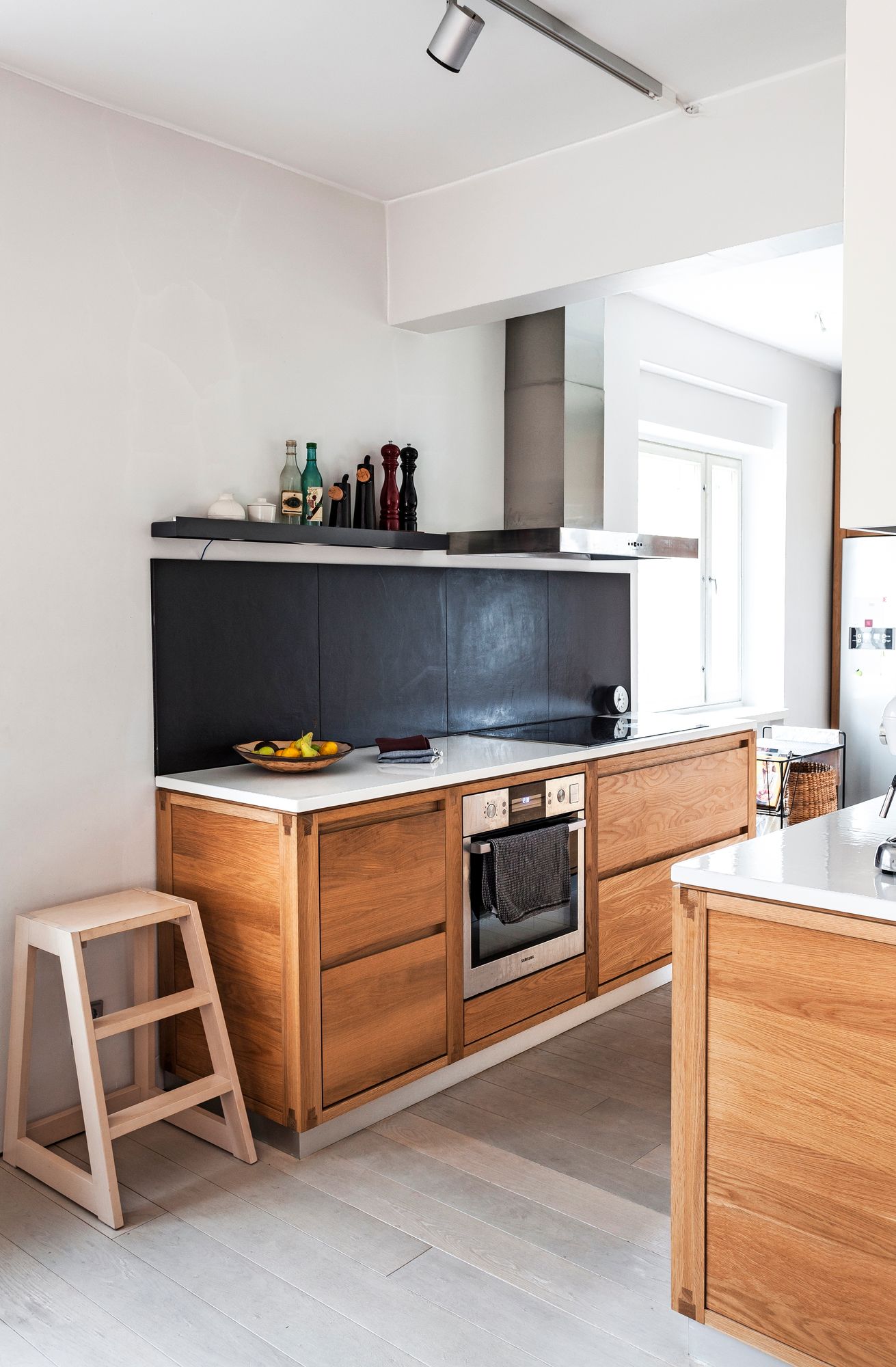 Suurikokoiset välitilan laatat rajaavat tehokkaasti keittiökaapistot pitkällä seinällä ja ovat helppohoitoiset.