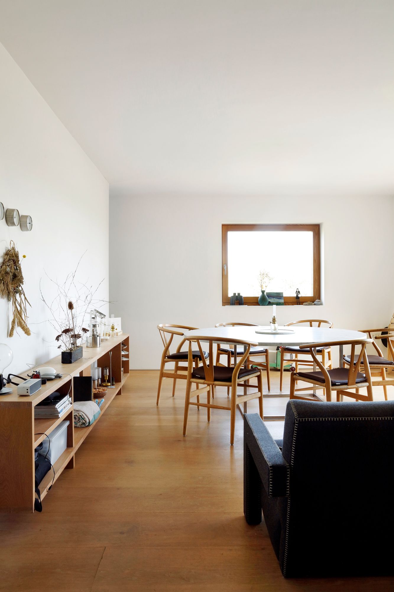 Marmoripöydät ja tarkoin valitut klassikkokalusteet tuovat tilaan arvokkuutta. Pöytä on tehty mittatilauksena ja sitä ympäröivät Hans Wegnerin Wishbone-tuolit.
