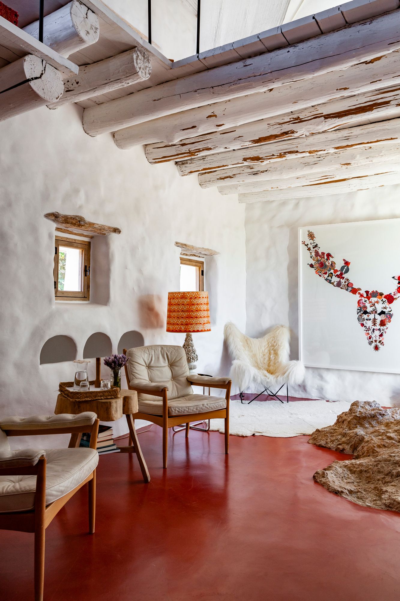 Vierashuoneessa on punainen mikrosementtilattia. Huone on ollut aikoinaan varasto ja kanala. Vintagenojatuolit on valmistanut tanskalainen Göte Möbler. Taideteos on espanjalaisen Marina Vargasin. 