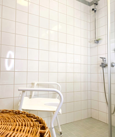 Kylpyhuoneeseen on tuotu arkea helpottava suihkutuoli. 