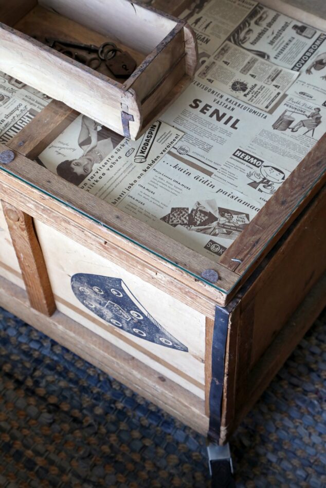 Vanhasta puulaatikosta saatiin pienellä tuunauksella lasikantinen sohvapöytä. Puisessa tiilimuotissa säilytetään kauko-ohjaimia.