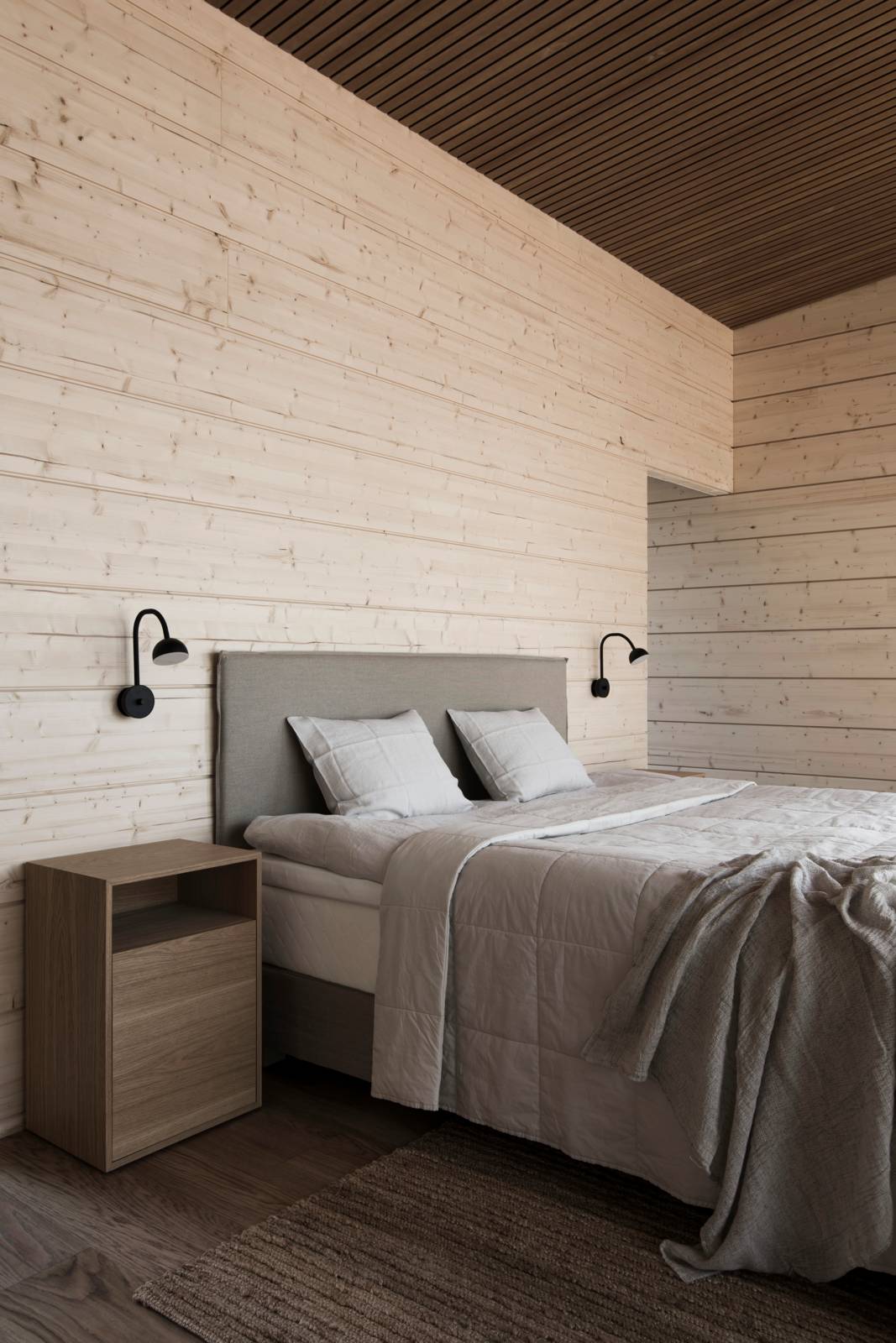 Villa Nordic Storiesin makuuhuoneessa leikitellään puun eri sävyillä.