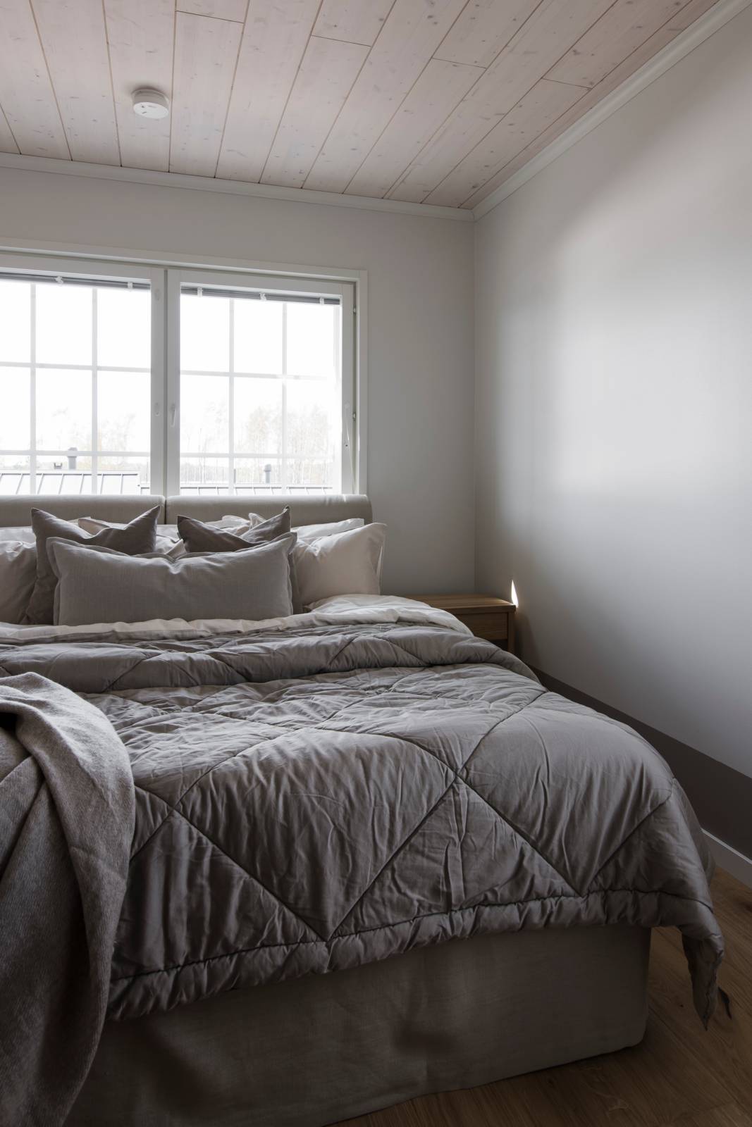 Designtalo Idyllin makuuhuoneen ylellisestä sängystä tulevat mieleen kiireettömät vapaapäivän aamut.