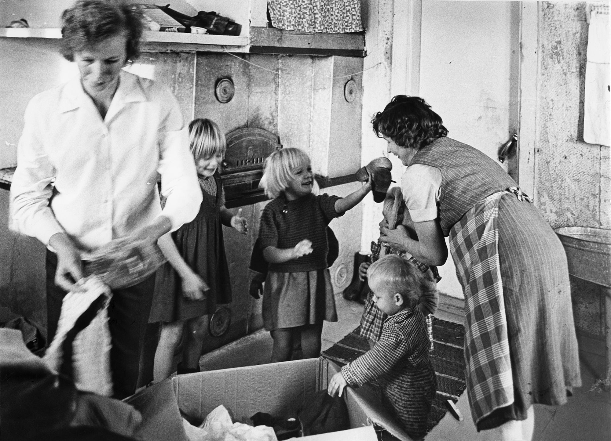 Perhe avaa Kotilieden Kummikerhon avustuspakettia vuonna 1963. 