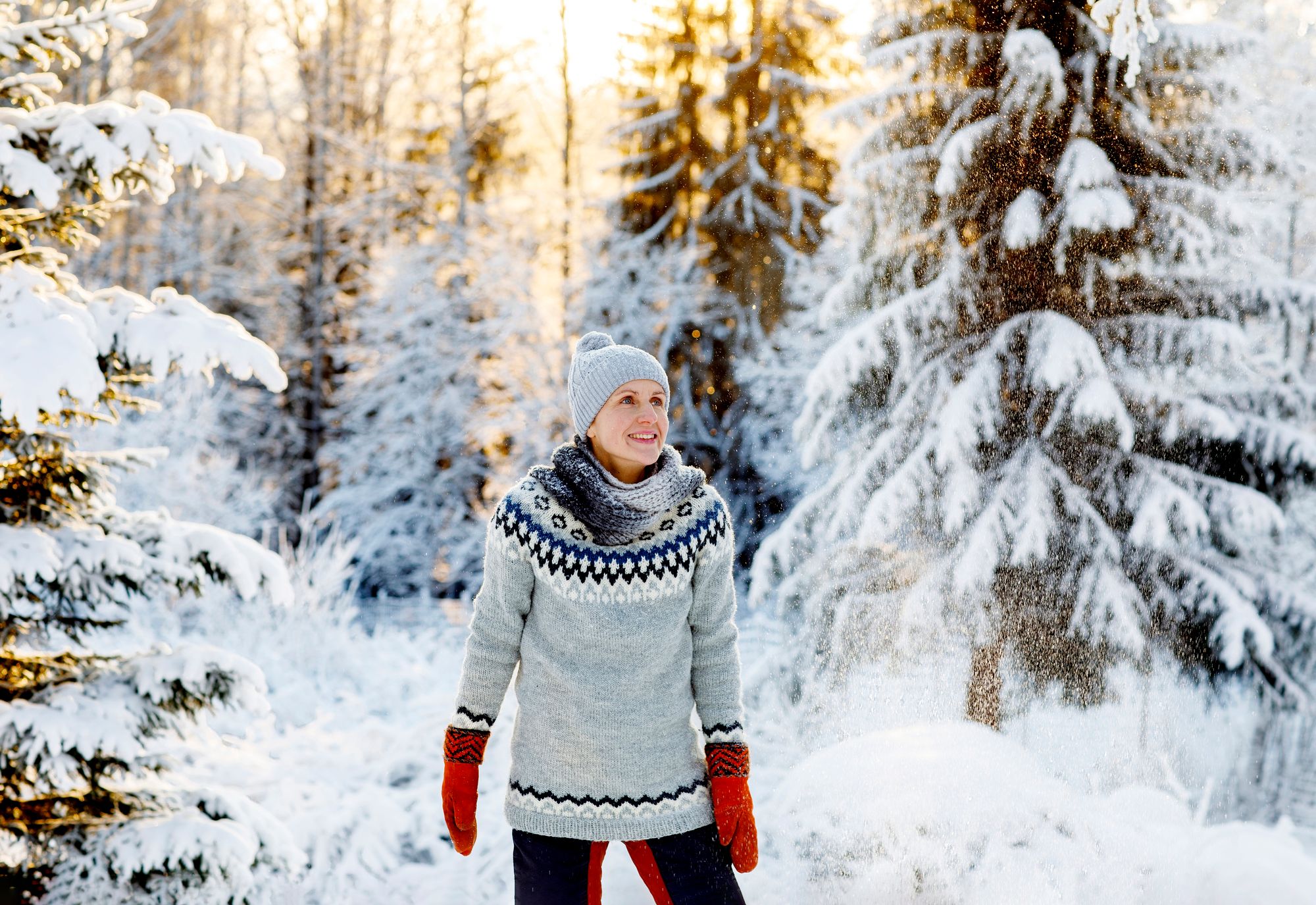 Maallemuuttoasiamies Johanna Niilivuo lumisessa metsässä.