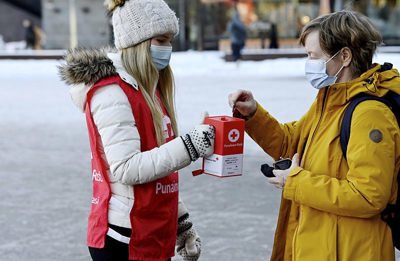 Ohikulkija lahjoitti SPR:n vapaaehtoisen pitämään lippaaseen Suomen Punaisen Ristin lipaskeräyksessä Ukrainan konfliktin uhreille Helsingissä 1. maaliskuuta 2022.