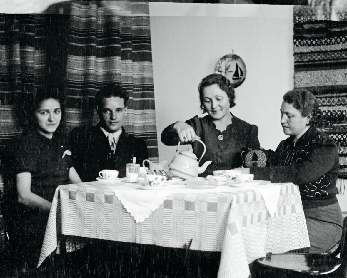 Kolme naista ja yksi mies kahvittelevat pöydän ääressä.