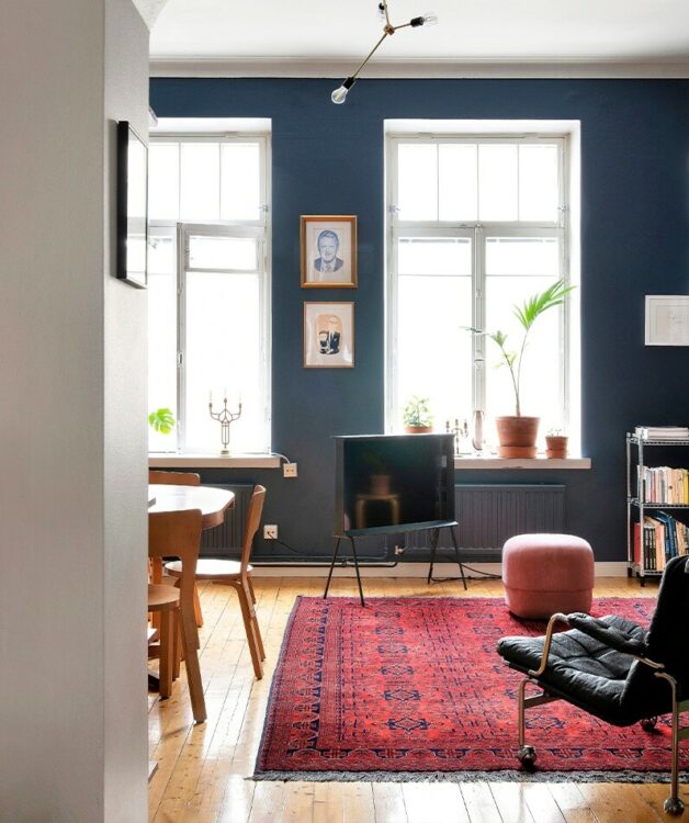 1. Maton avulla voi erotella olohuoneen oleskelutilan ruokailualueesta. Itämaisen maton tumma sininen toistuu seinän sävyssä.