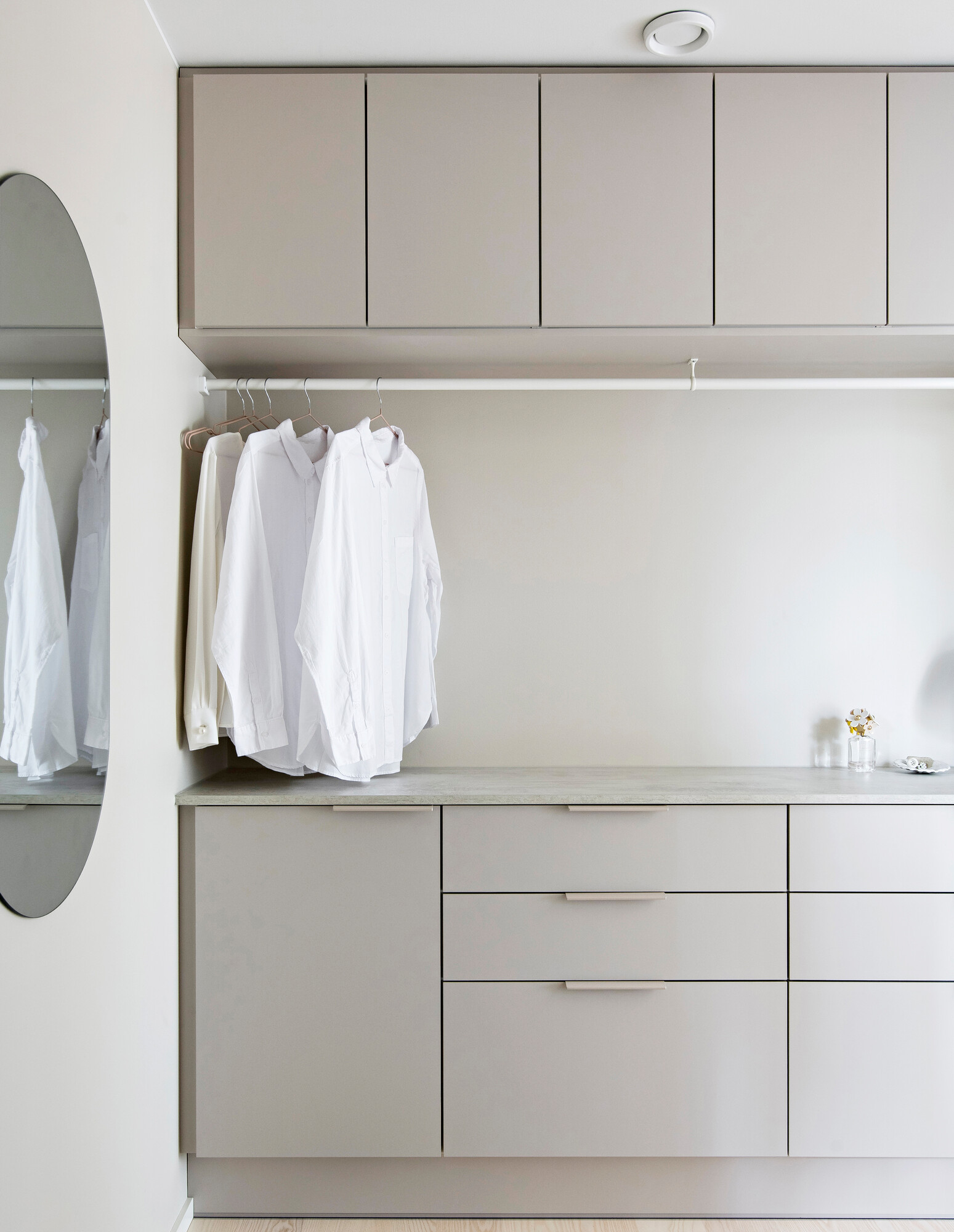 Yläkaappien alle on kiinnitetty vaatetanko, johon paidat saa kuivumaan suoraan pesukoneesta tai silityksen jälkeen. Pitkä taso toimii kodinhoitohuoneessa viikkauksessa ja lajittelussa.