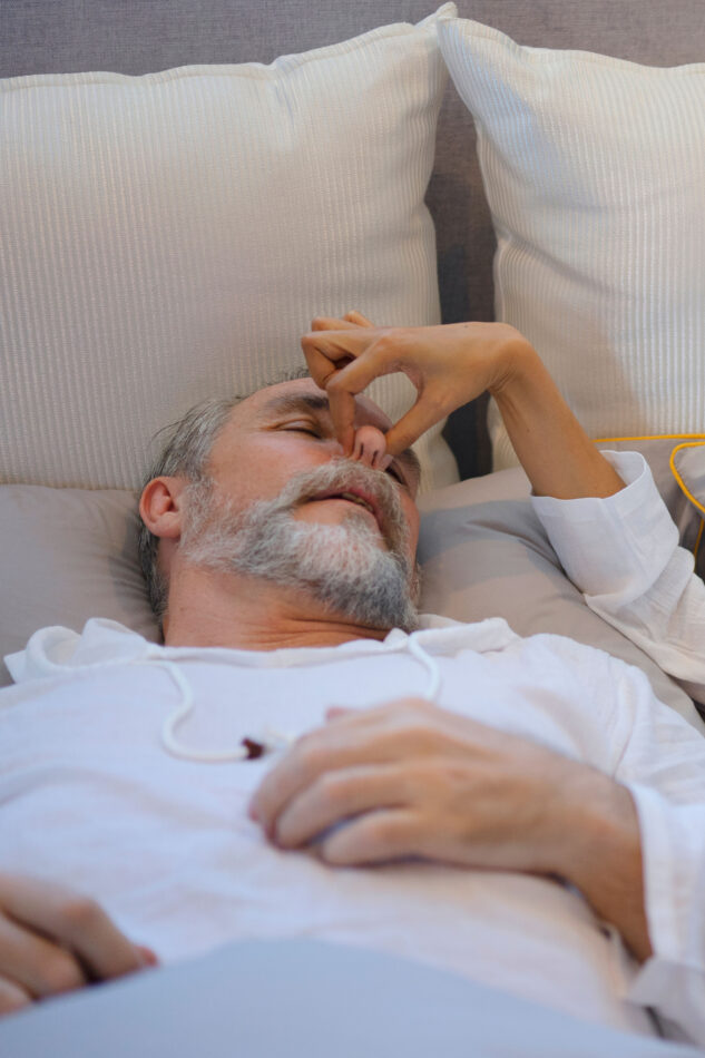 Kuorsauksen hoito, mistä apua kuorsaukseen? Käsi pitelee nukkujan nenää.